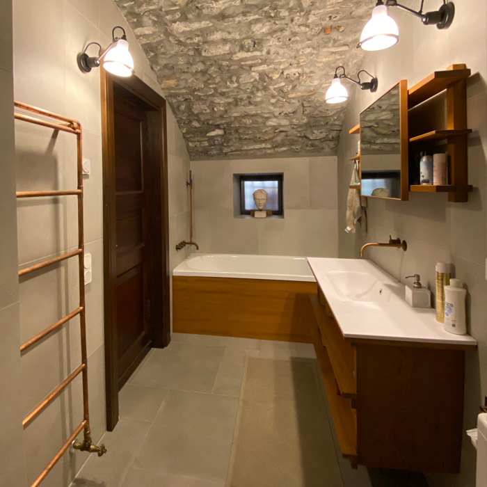 Stenvalv och varm träinredning i badrummet i Italienskt litet hus